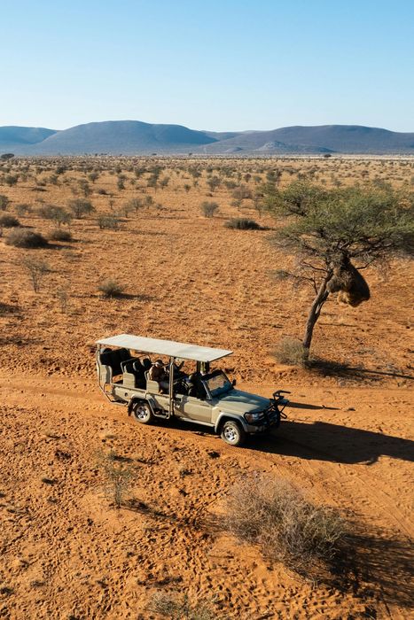 A safari jeep travels through Namibia's picturesque landscape